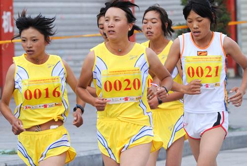 8月25日，获得第四届拉萨国际半程马拉松挑战赛女子第一名的美朵（左二）和第二名的次旺格桑（左一）在比赛中。当日，第四届拉萨国际半程马拉松挑战赛在拉萨举行，来自全国二十四个省区市和港澳地区的一千多名选手参加了比赛。新华社记者格桑达瓦摄