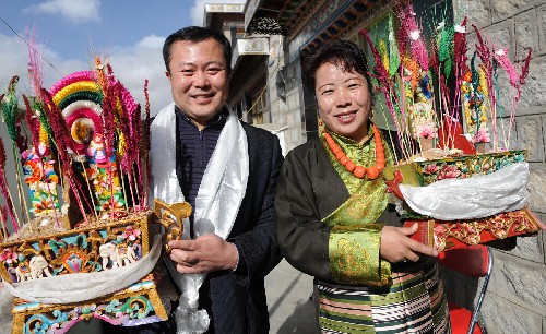 2月26日，来自北京石景山区的援藏干部刘盛杰（左）与藏族朋友安央金一起捧着吉祥的“切玛”合影。 当天是藏历土牛新年初二，在西藏堆龙德庆县工作的北京石景山区援藏干部来到该县羊达乡藏族农民家拜年，和他们一起欢度藏历新年。 新华社记者 索朗罗布 摄