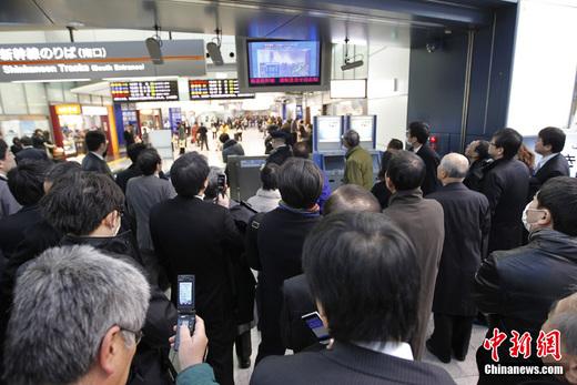 日本东京品川站受强震影响停运，旅客在车站内实时关注最新地震情况。