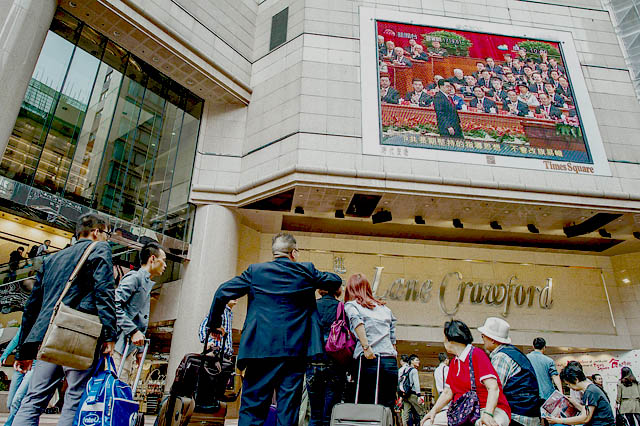 香港街头，人们通过大屏幕观看中国共产党第十八次全国代表大会开幕式的新闻报道。