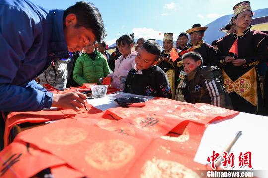 图为西藏自治区诗词楹联学会书法家为当地民众写春联、送祝福。　何蓬磊 摄