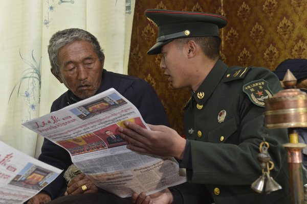 藏族战士帮助驻地老党员学习两会精神.JPG